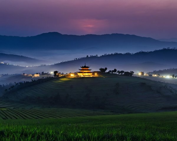 Traditional Building on Hill Surrounded by Terraced Fields and Misty Hills at Twilight