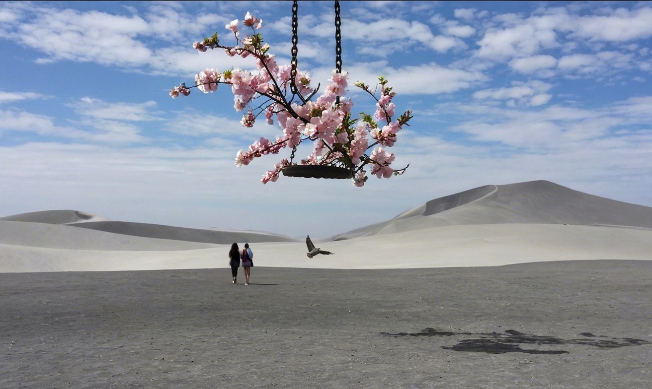 Surreal Desert Landscape with Figures and Cherry Blossoms