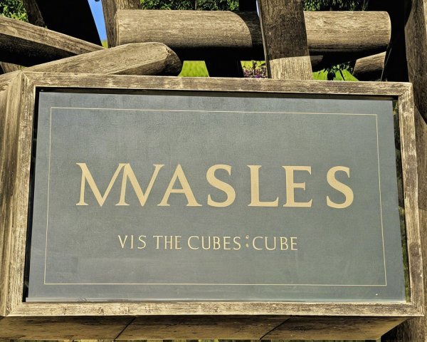 Wooden Sign with Stylized Text and Natural Elements