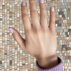 Stylized Hand with Light Blue Nails Against Abstract Art