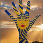 Giant Hand Sculpture in Vibrant Blue and Yellow Stripes