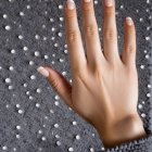Close-up of a woman's hand on a rainy window