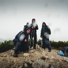 Outdoor gear person with llama, goats, sheep, and mountains