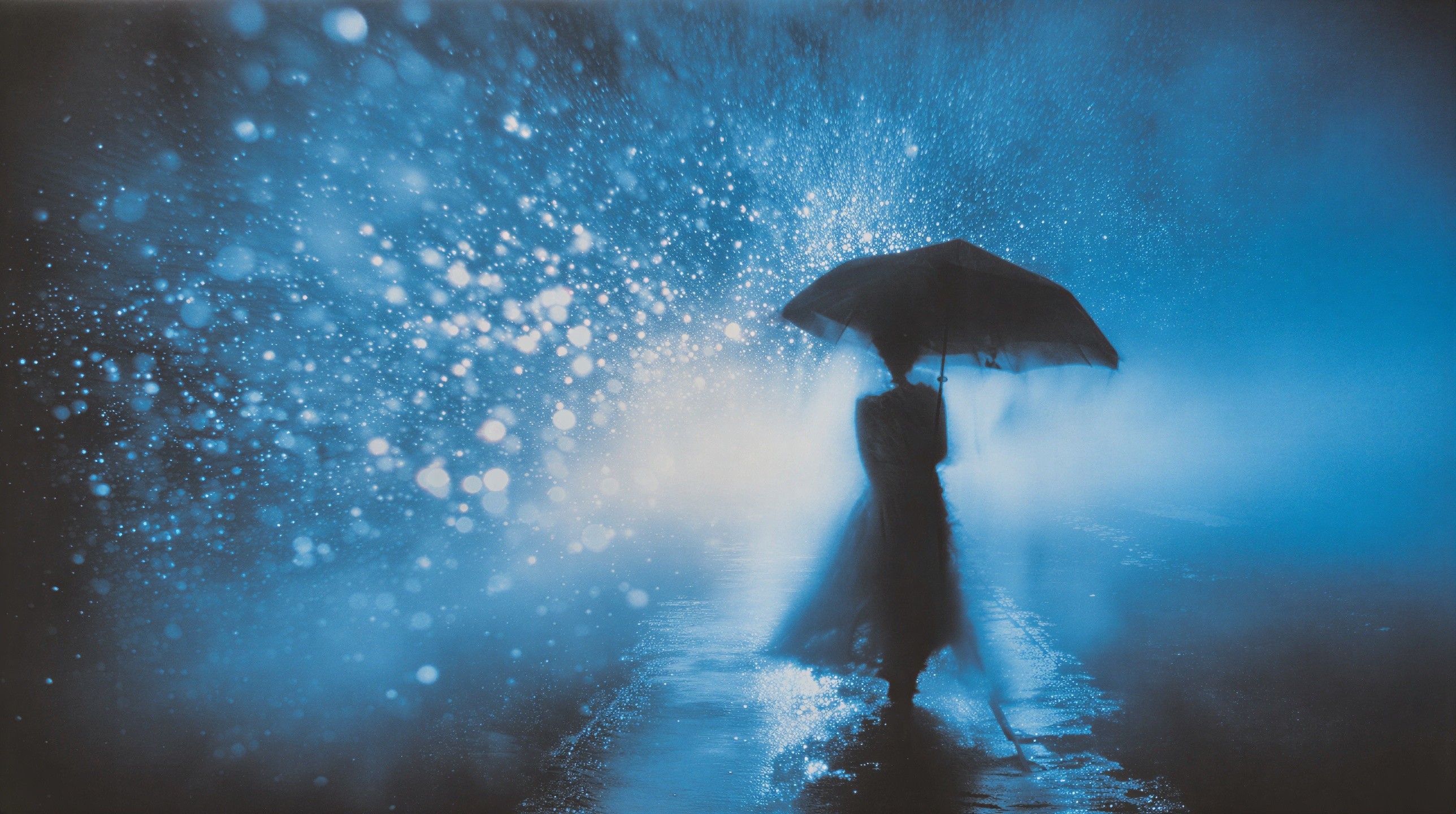 Cloaked Figure Under Umbrella in Misty Blue Scene