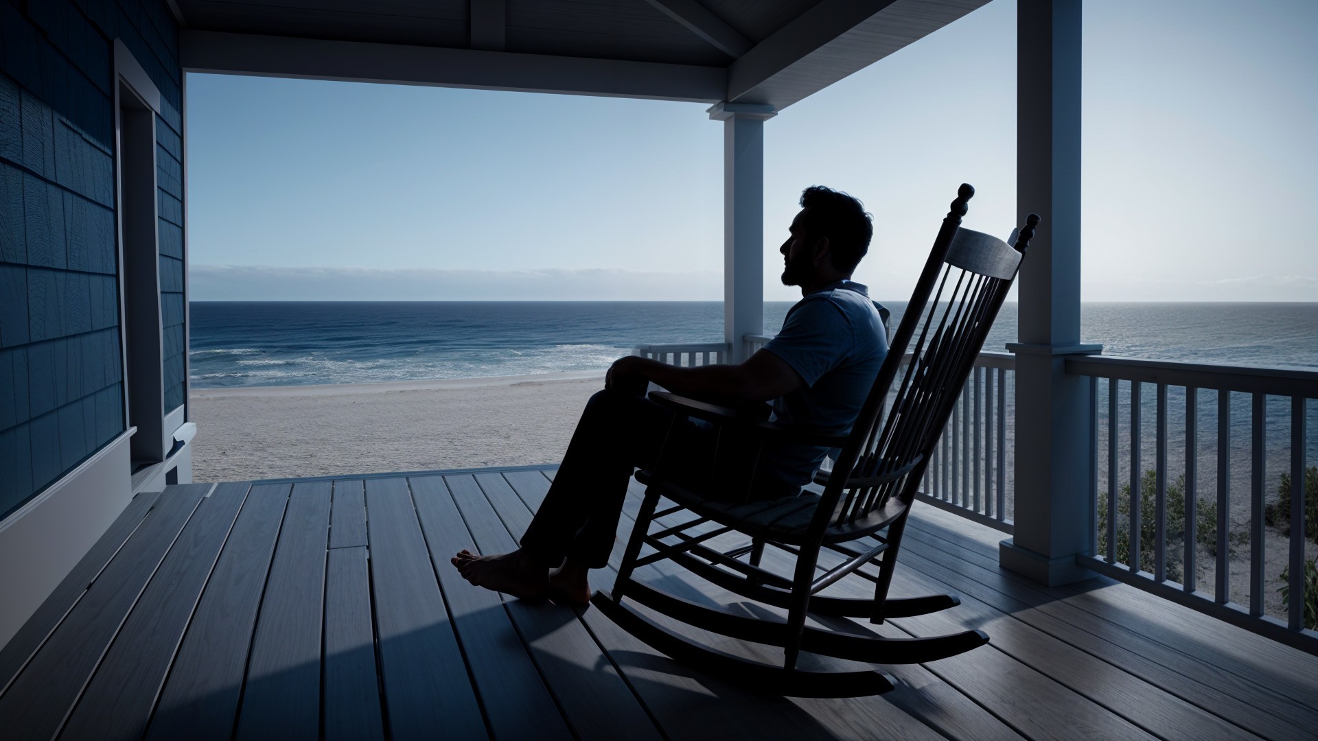 Silhouette of a man on a porch by the beach at dusk