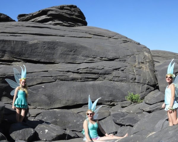 Young Women Dressed as Fairies on Rocks Under Blue Sky