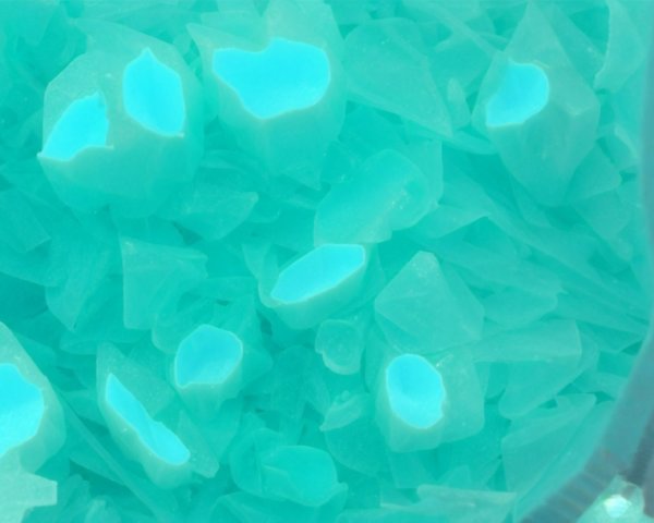 Vibrant Turquoise Wax-Like Fragments on Surface