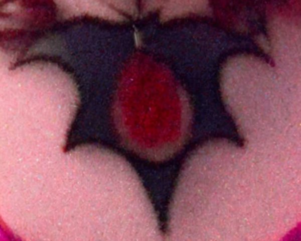 Close-up of a bat-shaped chest tattoo with gem detail