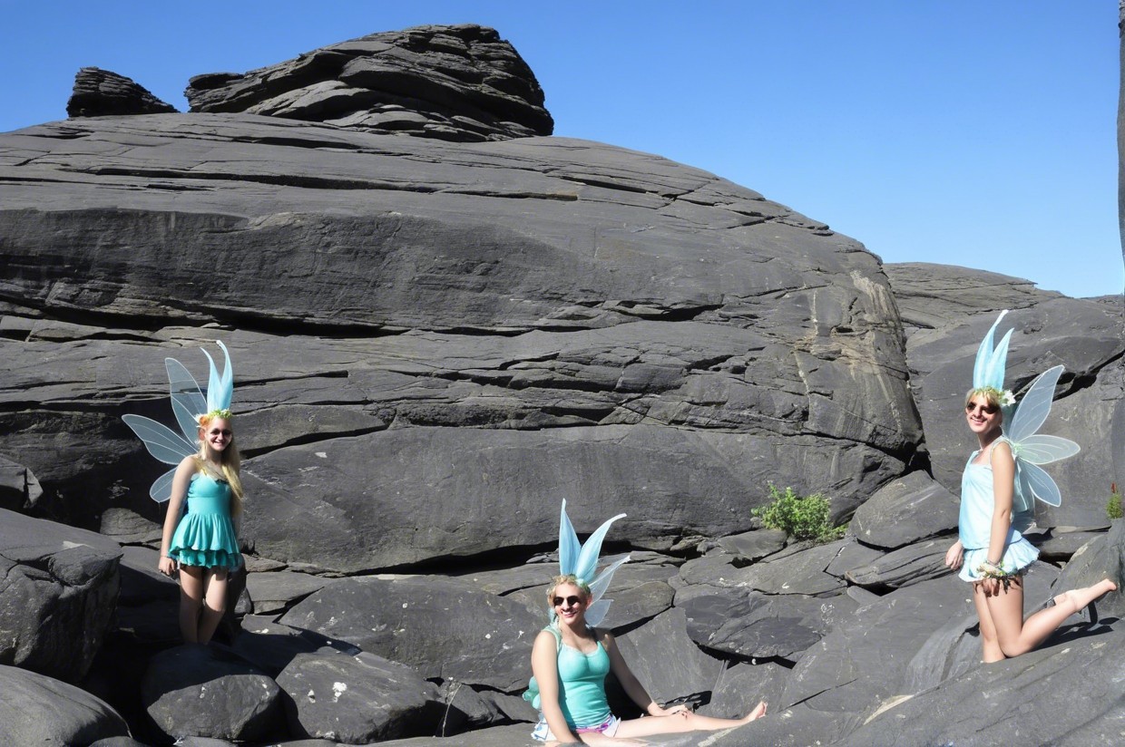 Young Women Dressed as Fairies on Rocks Under Blue Sky