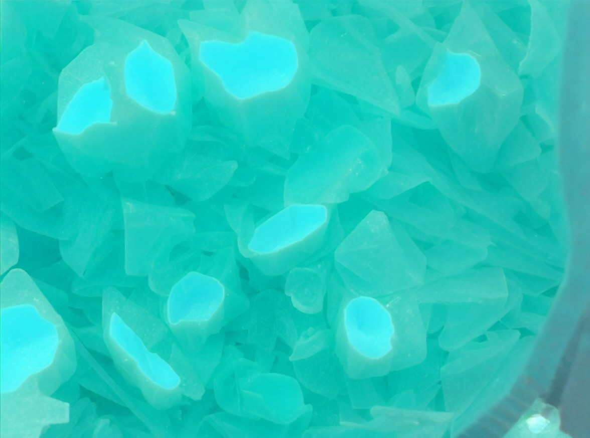 Vibrant Turquoise Wax-Like Fragments on Surface