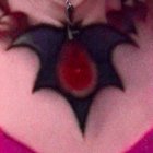 Close-up of a bat-shaped chest tattoo with gem detail