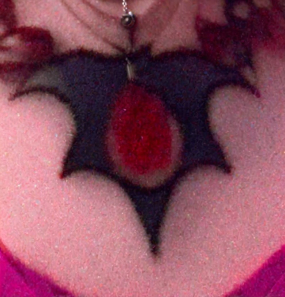 Close-up of a bat-shaped chest tattoo with gem detail