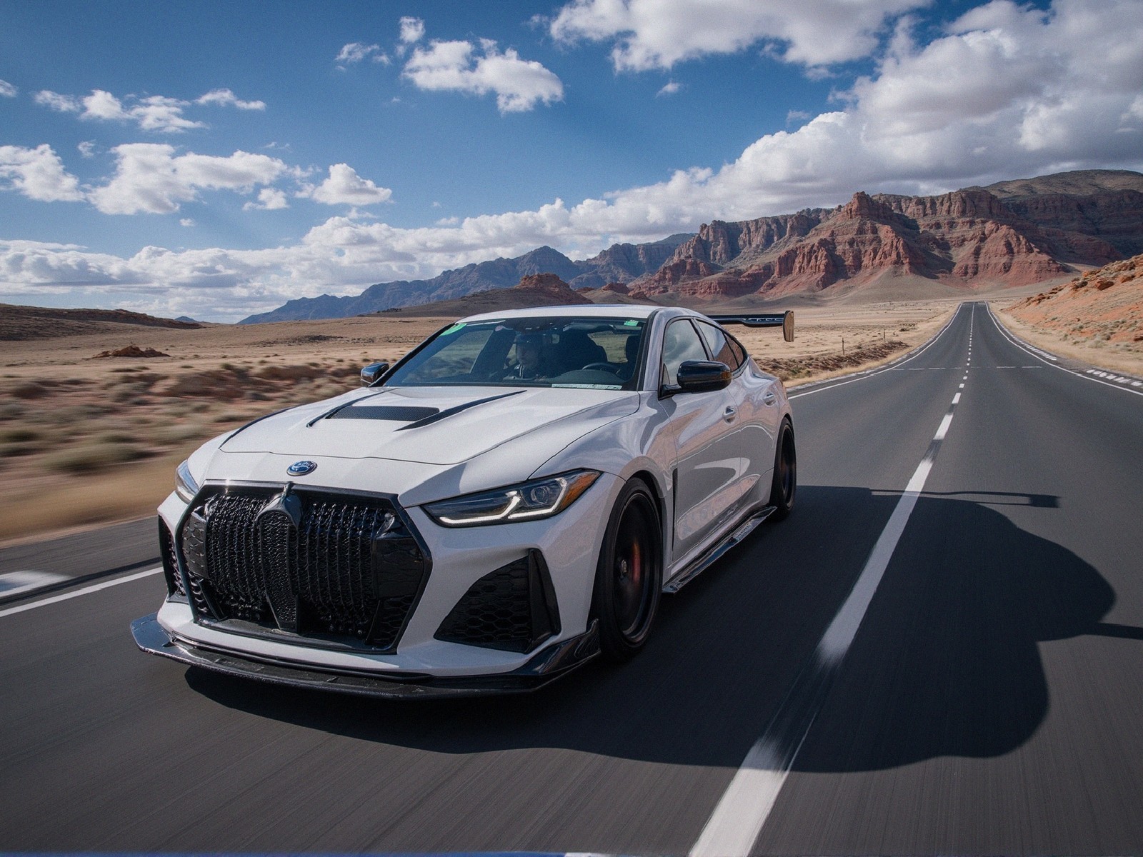 White Sports Car on Deserted Highway with Red Rocks