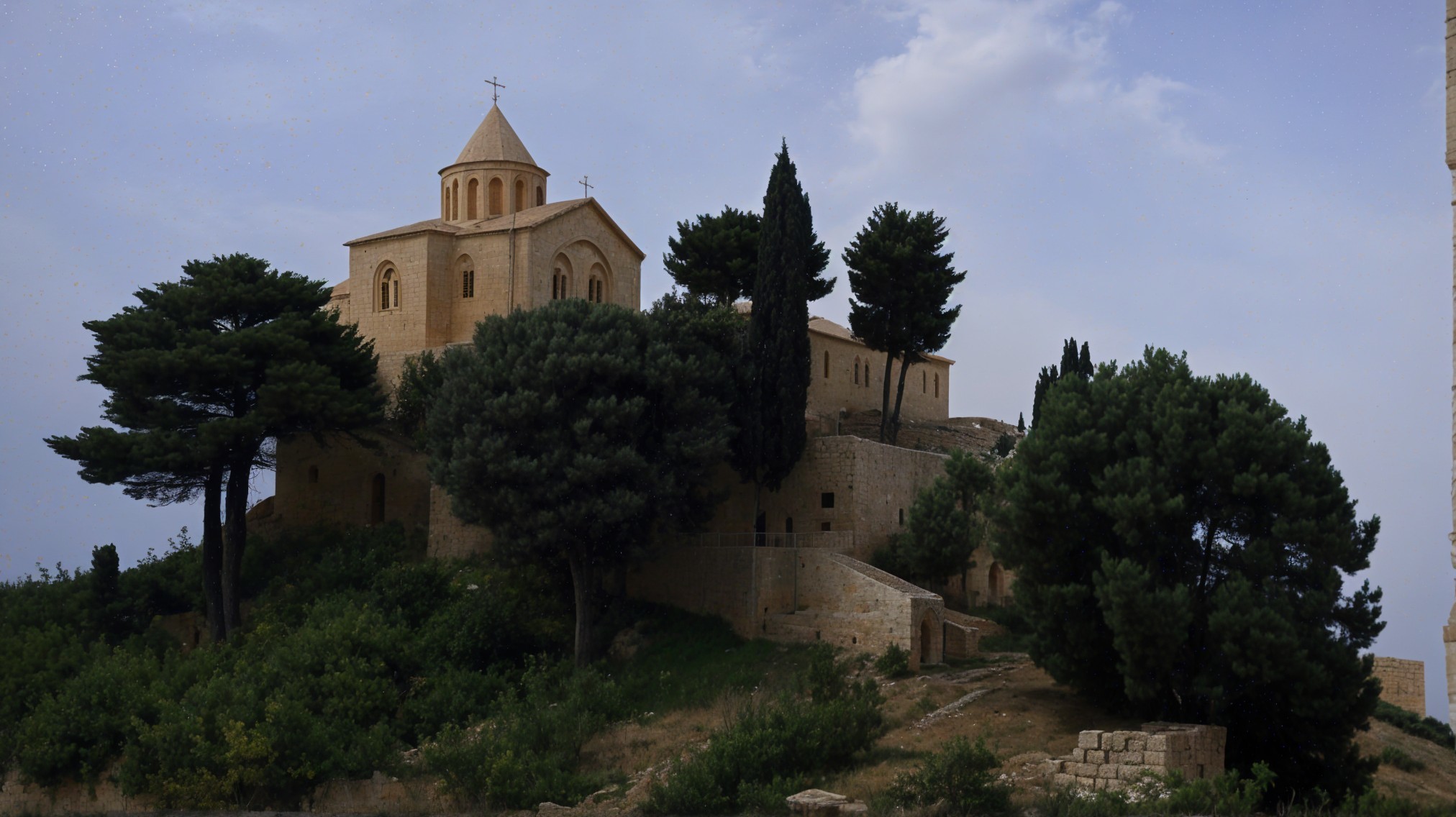 Stone Church on Hillside Surrounded by Lush Greenery