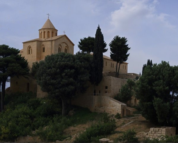 Stone Church on Hillside Surrounded by Lush Greenery