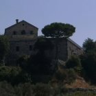 Stone Church on Hillside Surrounded by Lush Greenery