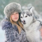 Woman Embracing Four Wolves in Snowy Forest