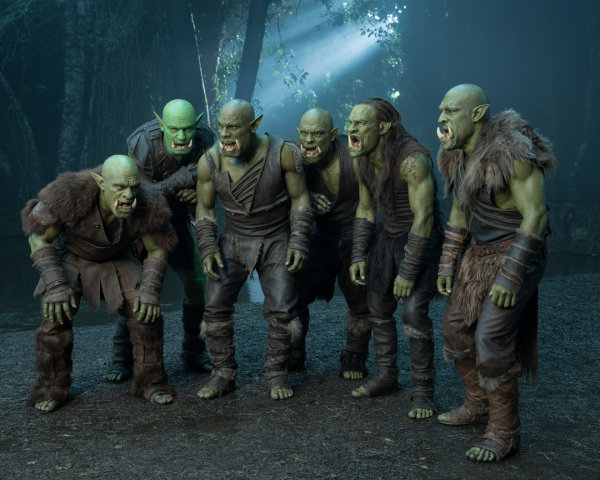 Group of six aggressive green-skinned orcs in forest