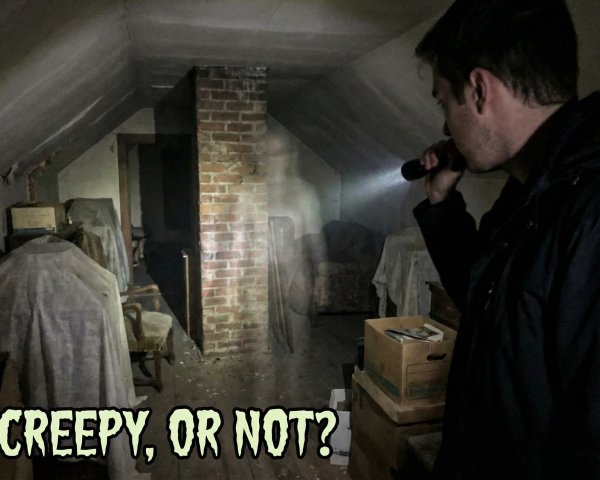 Young man with flashlight in creepy attic scene