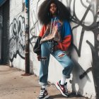 Young woman in oversized hoodie by graffiti wall