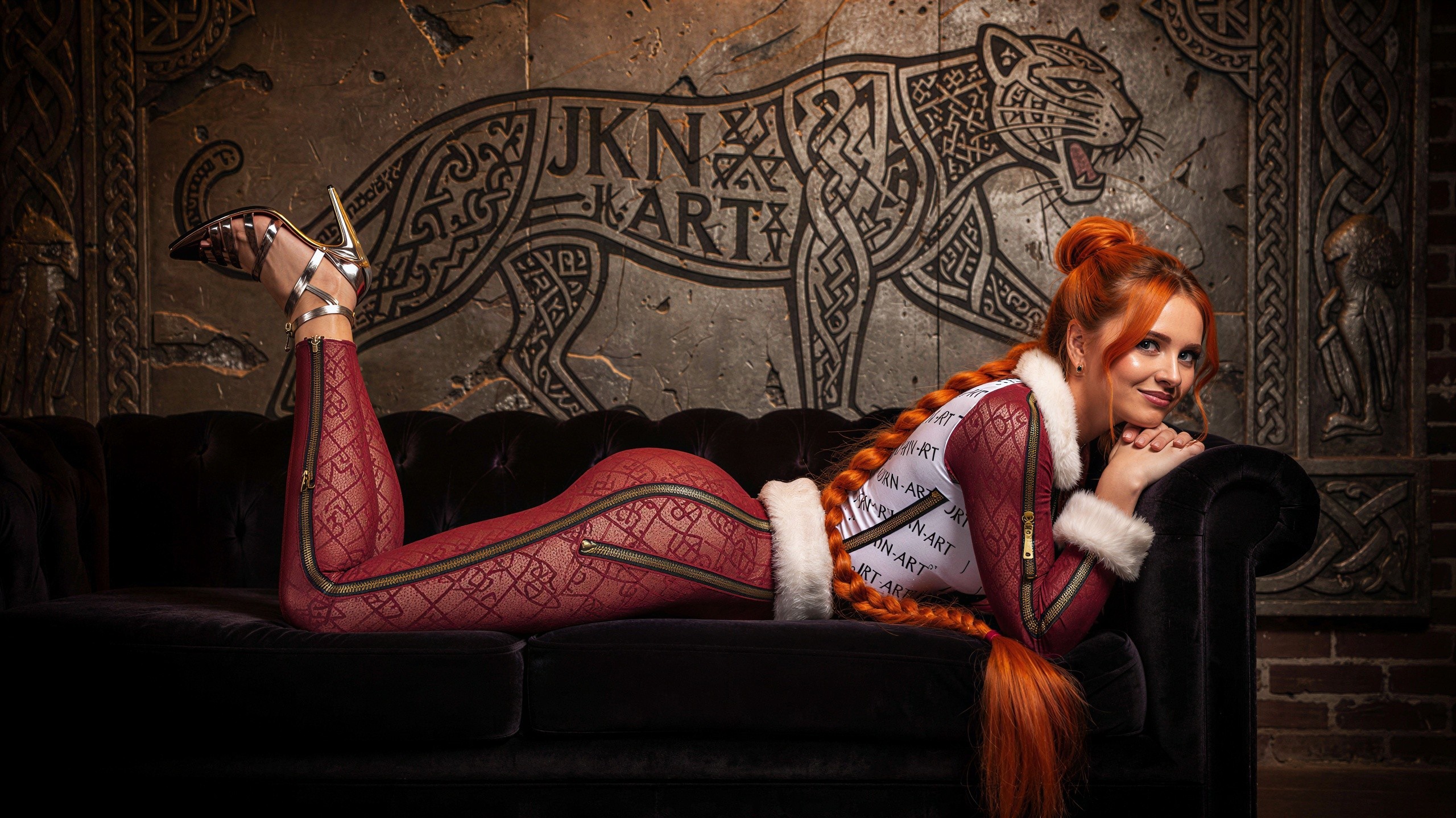 Woman with Red Braids on Sofa with Tribal Background