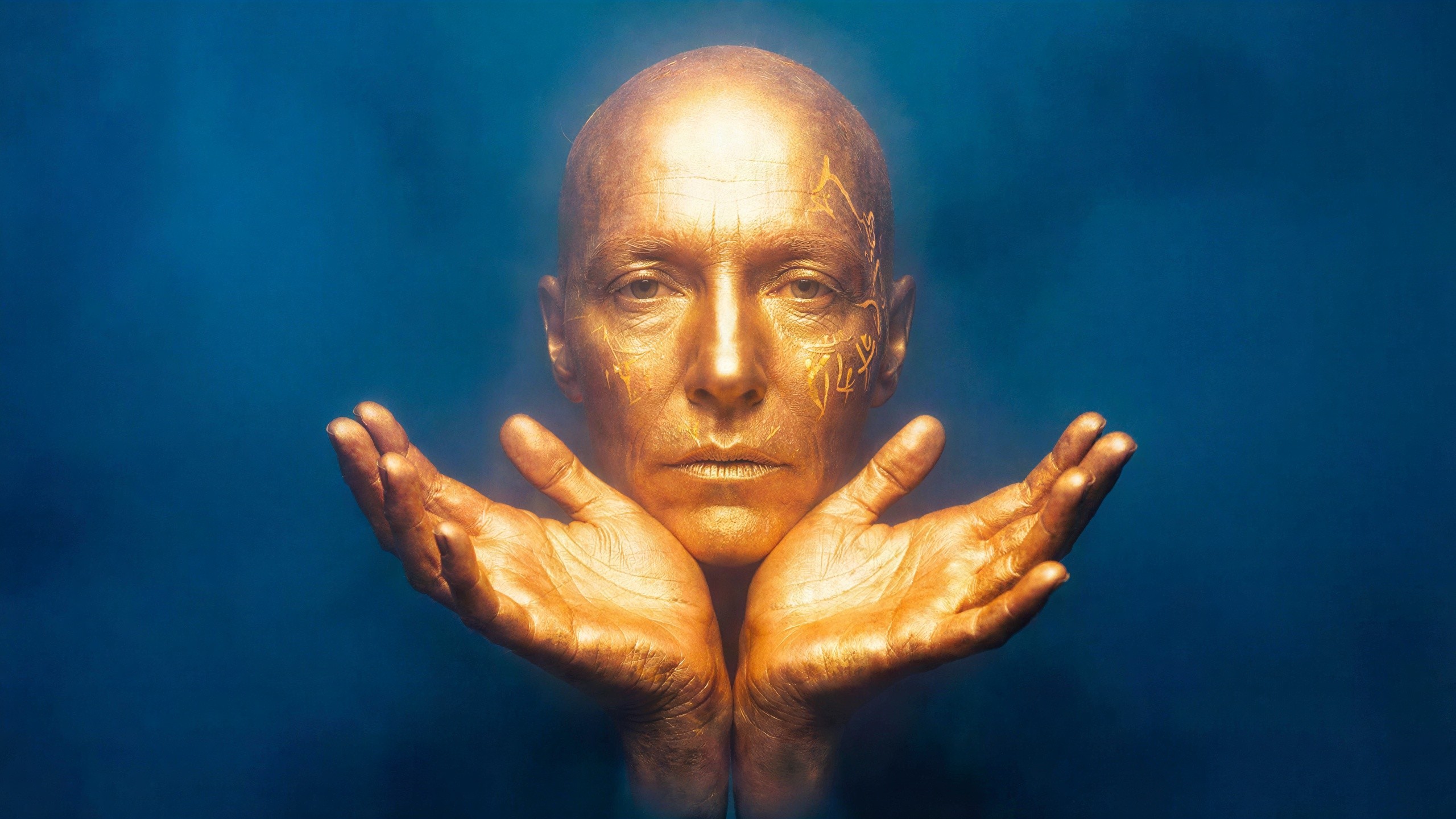 Golden Face Sculpture with Hands and Ancient Markings