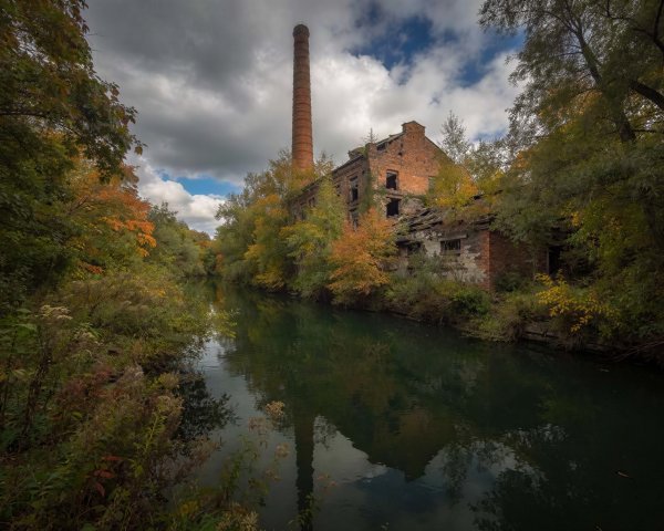 Wide-angle view of a serene river with autumn foliage