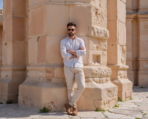 Stylish Man in Light Blue Shirt by Ancient Architecture
