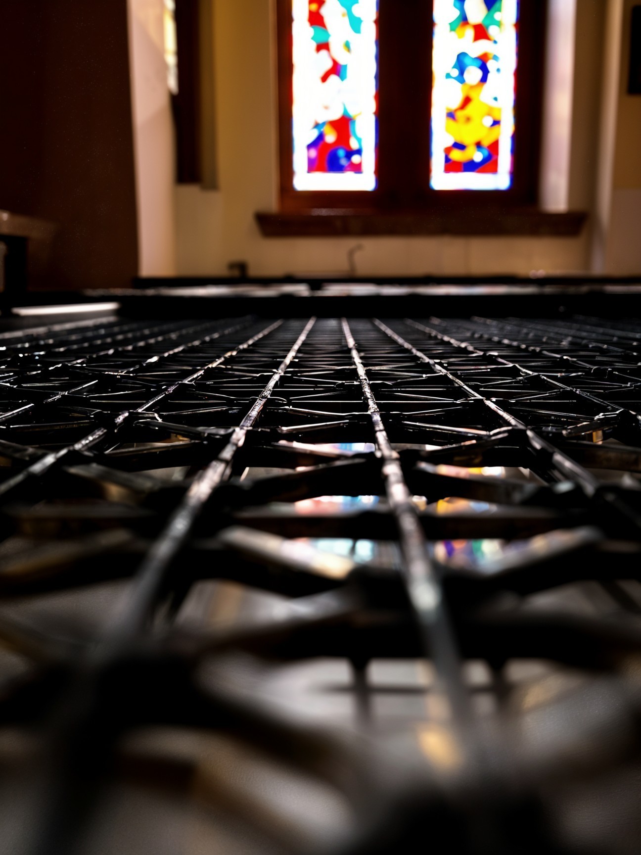 Close-up of Metal Grate with Stained Glass Reflections