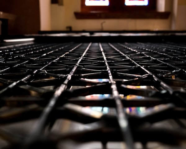 Close-up of Metal Grate with Stained Glass Reflections