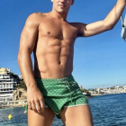 Young man by swimming pool with blue sky backdrop