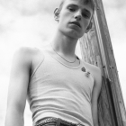 Muscular Man in Chains Against Wooden Post in Monochrome