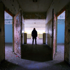 Lone Figure Between Two Illuminated Doors in Landscape
