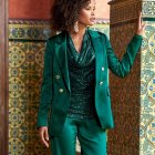 Elegant woman in emerald green suit with textured backdrop
