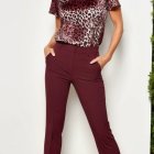 Confident Woman in Leopard-Print Top and Burgundy Trousers