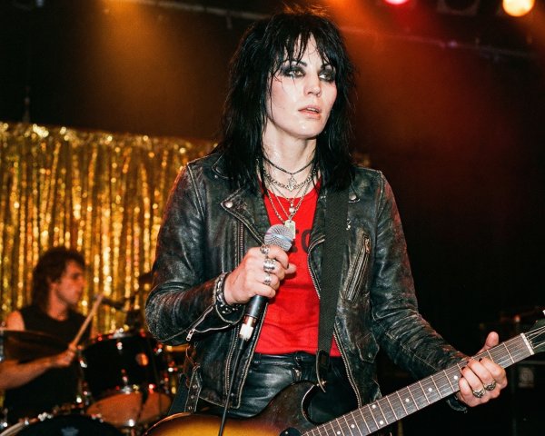 Androgynous Musician Performing on Stage with Band Member
