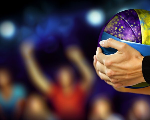 Close-up of a hand holding a colorful basketball