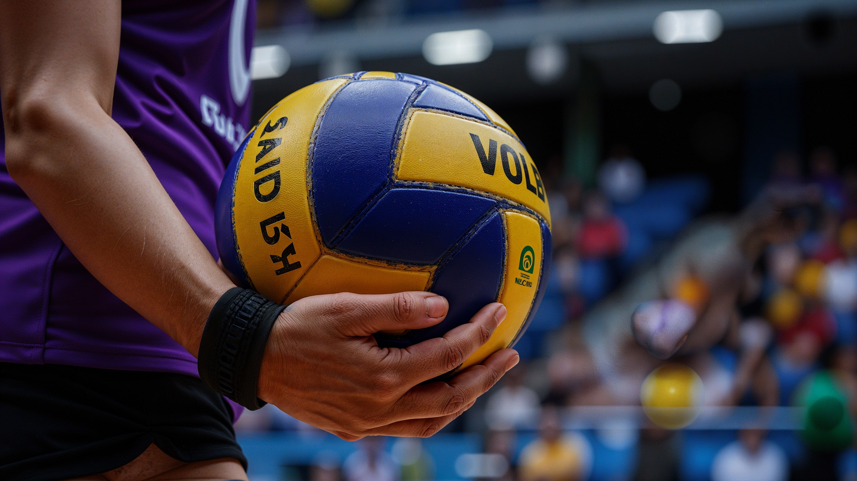 Close-up of Hand Gripping Blue and Yellow Volleyball
