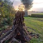 Mystical figure in greenery under a radiant sunset