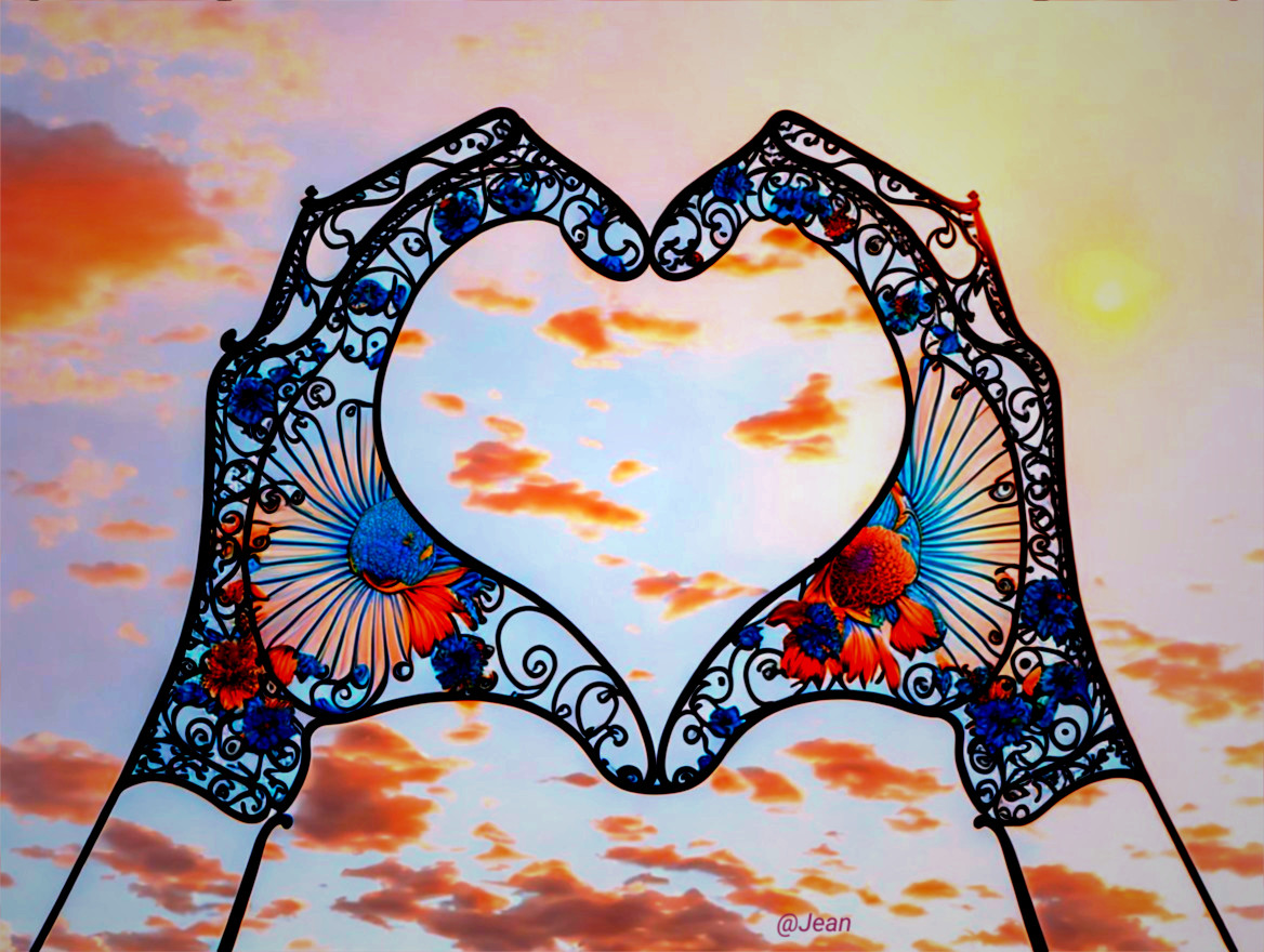 Hands Forming Heart Shape Against Sunset Background
