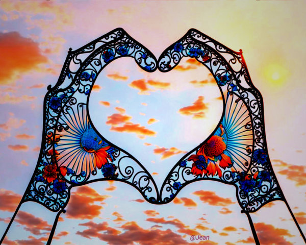 Hands Forming Heart Shape Against Sunset Background