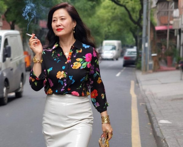 Elegant Asian woman in floral shirt and pencil skirt