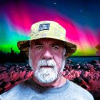 Man with Gray Beard in Floral Hat Against Northern Lights