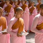 Children in Orange Robes at a Temple with Buddha Statue