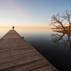 Wooden Dock at Sunset Over Calm Waters with Figure