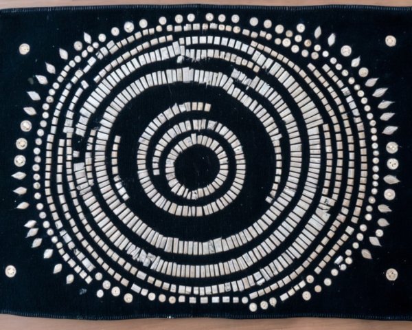 Circular Textile Design with White Pieces on Black Background