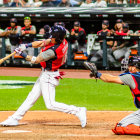 Baseball Player Swings Bat in Lively Stadium Scene