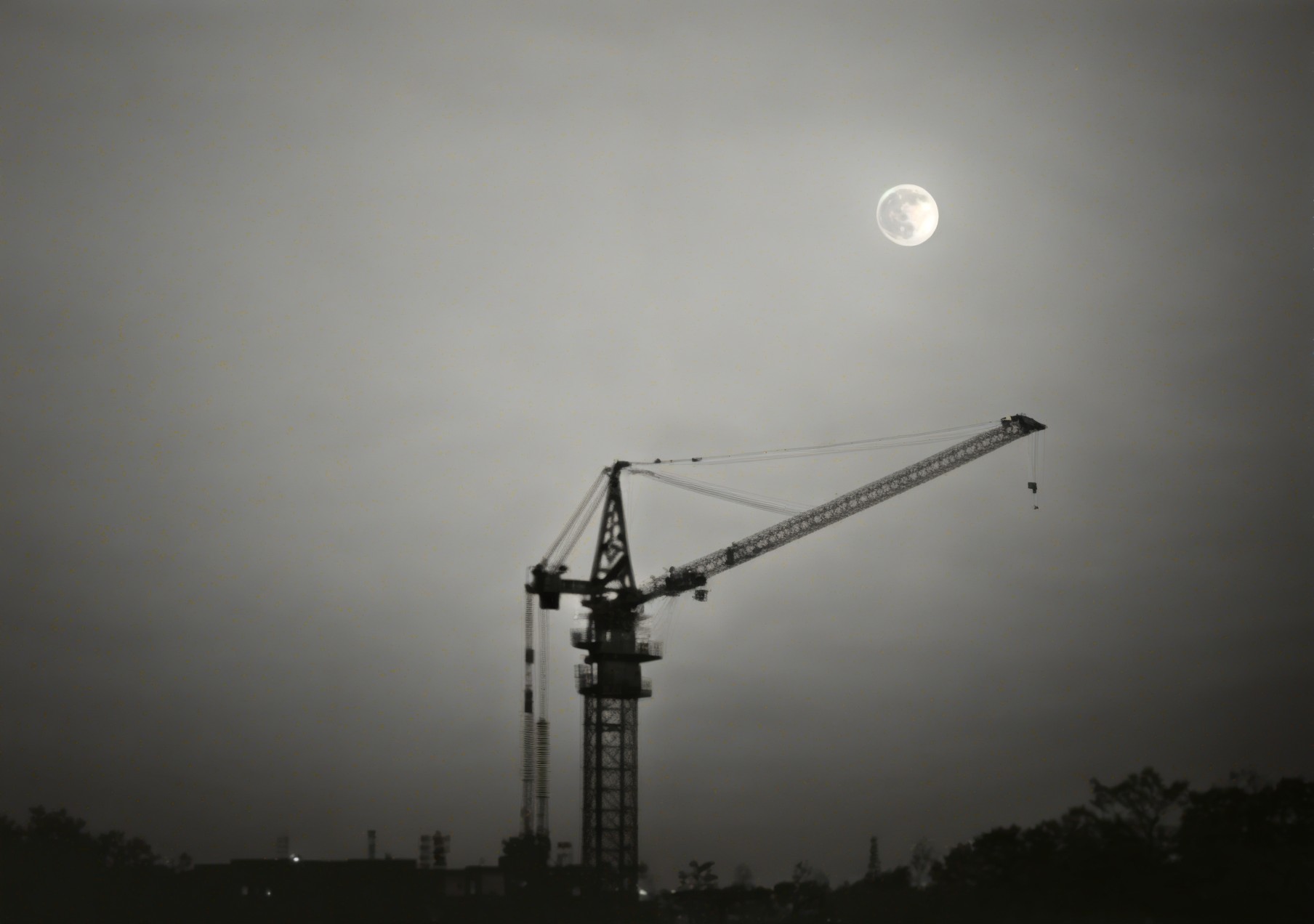 Construction Crane Silhouetted by Full Moon and Sky
