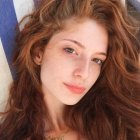 Young woman with brown hair and glowing skin