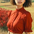 Young Woman in Stylish Outfit Against Mountain Scenery